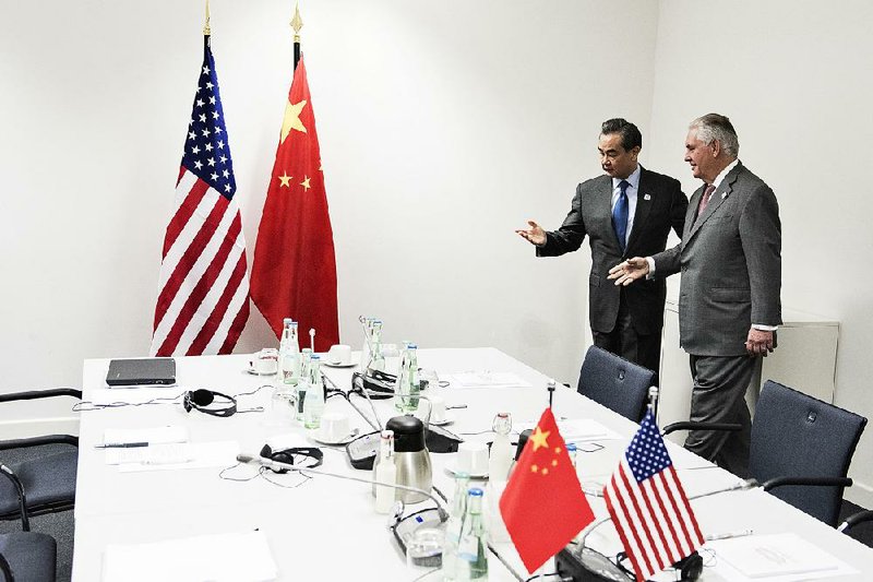 U.S. Secretary of State Rex Tillerson (right) talks with Chinese Foreign Minister Wang Yi before a meeting Friday in Bonn, Germany