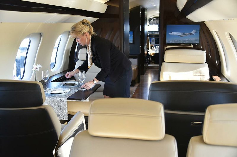An employee arranges a table inside a Bombardier Inc. Global 7000 Business Jet aircraft during the National Business Aviation Association Convention & Exhibition in Orlando, Fla. in November.