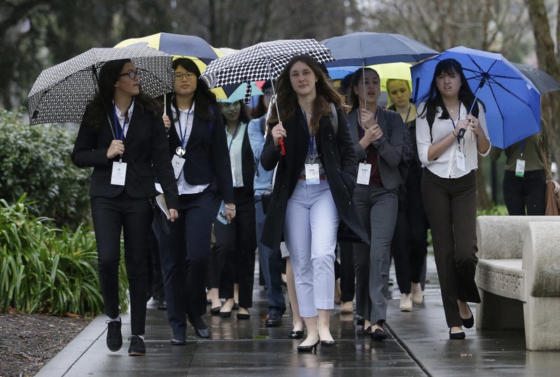 Umbrellas were put to use as a group of students walk to the Sacramento Convention Center to attend the YMCA Model Legislature & Court, Friday, Feb. 17, 2017, in Sacramento, Calif. Storms continued to batter California as the saturated state faces another round of wet weather that could trigger flooding. 