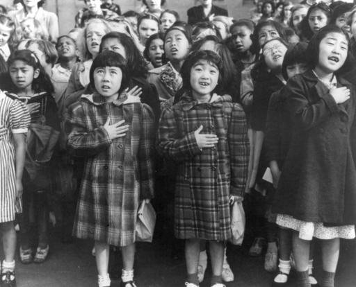 In this April 1942 photo made available by the Library of Congress, children at the Weill public school in San Francisco recite the Pledge of Allegiance. Some of them are evacuees of Japanese ancestry who will be housed in War Relocation Authority centers for the duration of the war. 