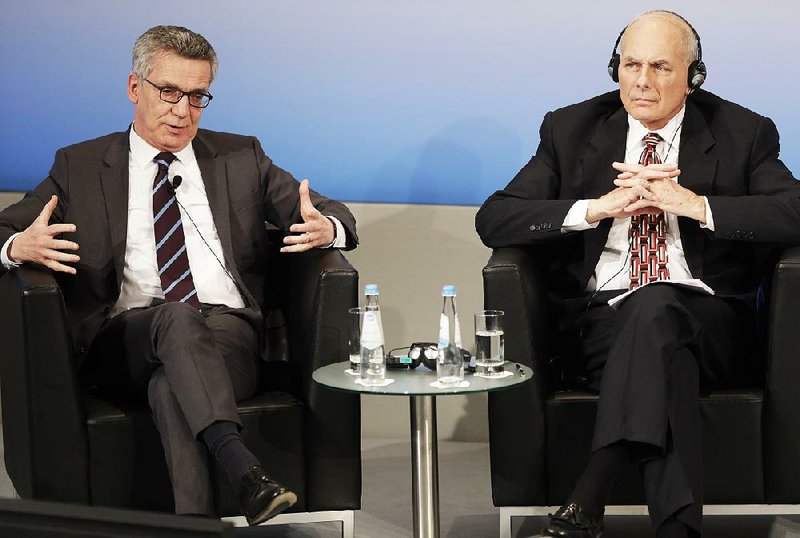 German Interior Minister Thomas de Malziere (left) and U.S. Homeland Security Secretary John Kelly take part in a panel discussion on terrorism Saturday at the Munich Security Conference. Kelly said President Donald Trump is developing a revised version of his courtblocked travel ban for seven predominantly Muslim nations.