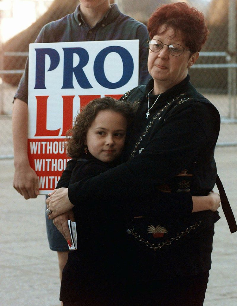 In this Jan. 22, 1997, file photo, Norma McCorvey, right, known as Jane Roe in the landmark U.S. Supreme Court ruling 24 years ago that legalized abortion nationwide, stands with her friend Meredith Champion, 9, at an Operation Rescue rally in downtown Dallas. Norma McCorvey, the "Jane Roe" at the center of the 1973 U.S. Supreme Court decision that legalized abortion, has died.