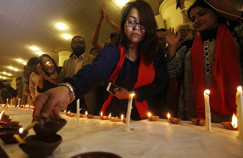 People light candles and oil lamps Saturday in memory of the people killed in Thursday’s suicide bombing at a shrine in southern Pakistan.