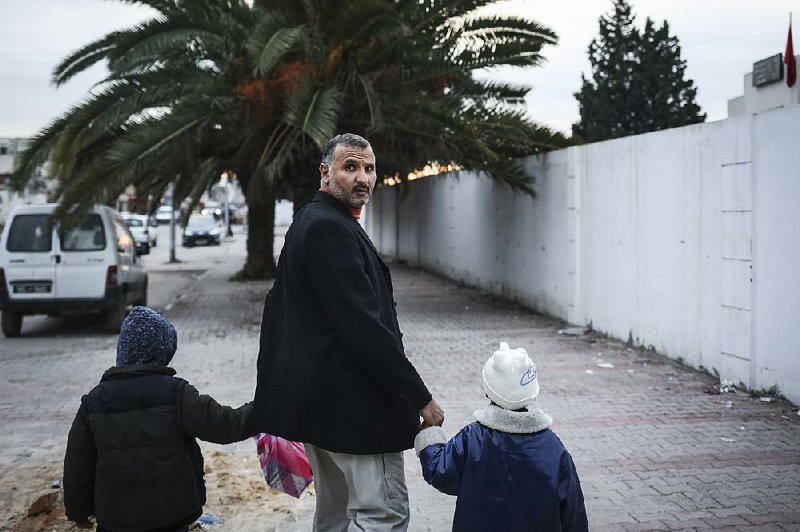 Hedi Hammami takes his children home from day care in December in Tunis, Tunisia. “I have lost my hope,” Hammami said. “There is no future in this country for me.”