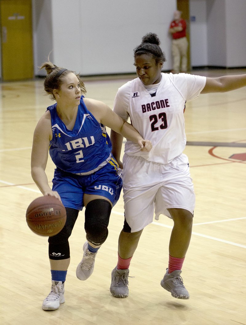 Photo submitted John Brown freshman Sara Williams, left, brings the ball up the floor against Bacone (Okla.) on Thursday.