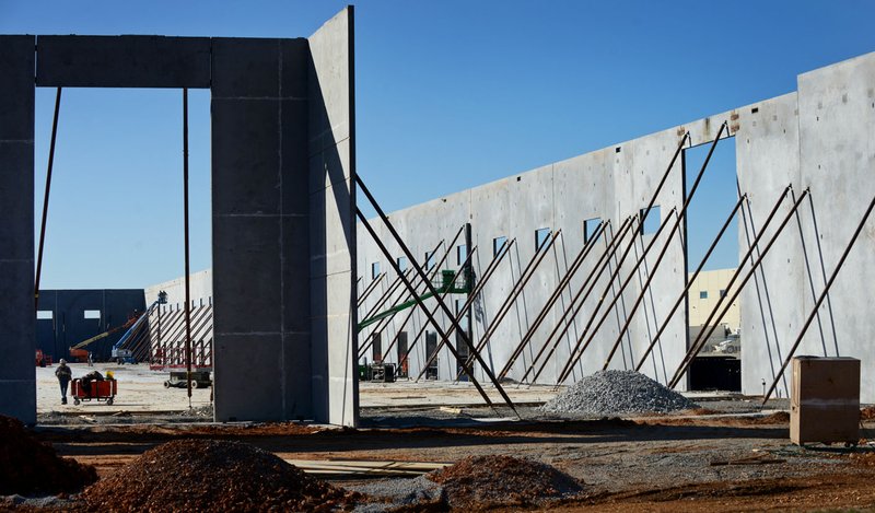 Construction progesses Thursday at a commercial building taking shape on Southwest Regional Airport Boulevard in Bentonville. Officials are considering changing the four council wards because the populations have become unbalanced.