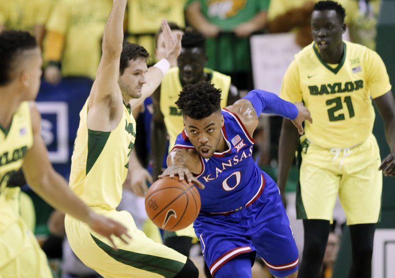 The Associated Press STRETCHING OUT: Kansas guard Frank Mason III (0) reaches out to secure a rebound in front of Baylor's Jake Lindsey, center left, and Nuni Omot (21) in the first half Saturday in Waco, Texas.