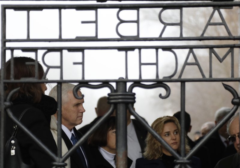 U.S. Vice President Mike Pence, his wife Karen and his daughter Charlotte, from left, stand behind the gate with the infamous writing "Work sets you free" as they visit the former Nazi concentration camp in Dachau near Munich, southern Germany, Sunday, Feb. 19, 2017, one day after he attended the Munich Security Conference. 
