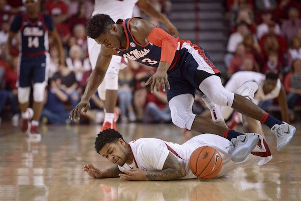 Anton Beard of Arkansas and Terence Davis of Ole Miss dive for a loose ball in the first half Saturday, Feb. 18, 2017, during the game at Bud Walton Arena in Fayetteville.
