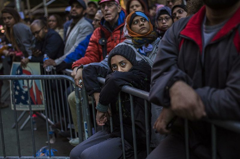 People listen to speakers Sunday in Times Square in New York during a rally in support of Muslim Americans and in protest of President Donald Trump’s immigration policies.