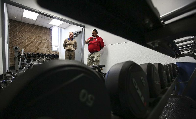 Terry Hartwick (left), head of the city Parks and Recreation Department, and Tony Pate, center director, talk about the expansion of the weight room at the North Little Rock Community Center on Friday.