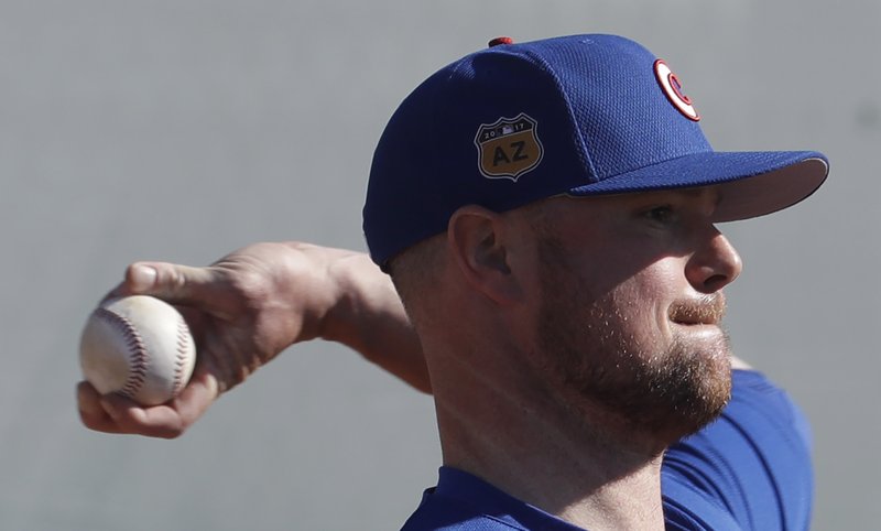 The Associated Press LET 'ER FLY: Chicago Cubs' Jon Lester throws during a spring training baseball workout last week in Mesa, Ariz.