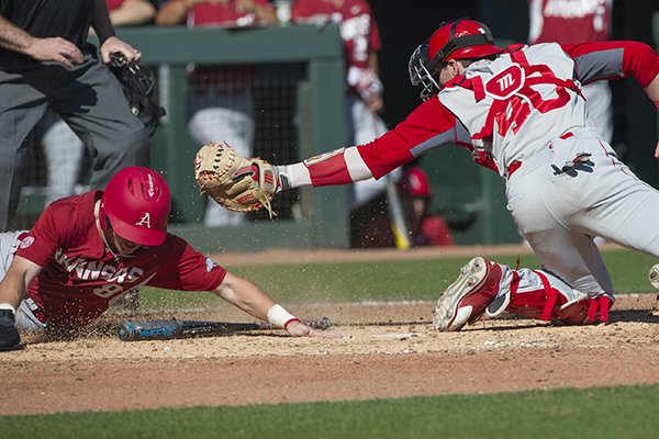 Arkansas' Eric Cole scores under the tag attempted by Miami's Hayden Senger in the fifth inning Sunday, Feb. 19, 2017. The Hogs won 11-1.