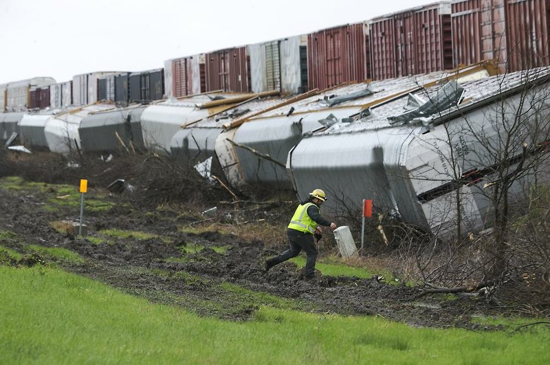 A worker walks near a train that derailed early Monday in Thrall, Texas, after severe storms moved through area.
