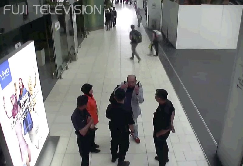 In this image made from Feb. 13, 2017, airport closed circuit television video and provided by Fuji Television, Kim Jong Nam, exiled half-brother of North Korea's leader Kim Jong Un, gestures towards his face while talking to airport security and officials at Kuala Lumpur International Airport, Malaysia. Kim Jong Nam, the estranged half brother of North Korean ruler Kim Jong Un, died last week after apparently being poisoned in a Kuala Lumpur airport. 