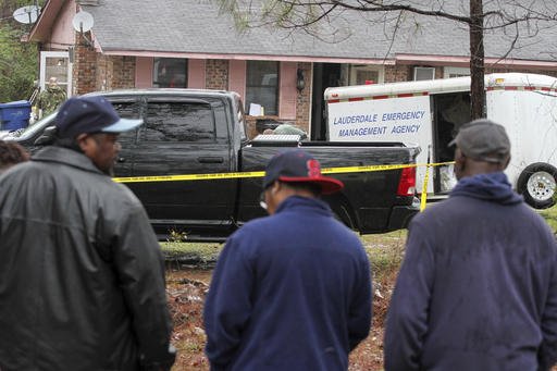 Family members and friends look on as Lauderdale County authorities investigate the shooting deaths of four members of a family in Toomsuba, Miss., on Tuesday, Feb. 21, 2017. 