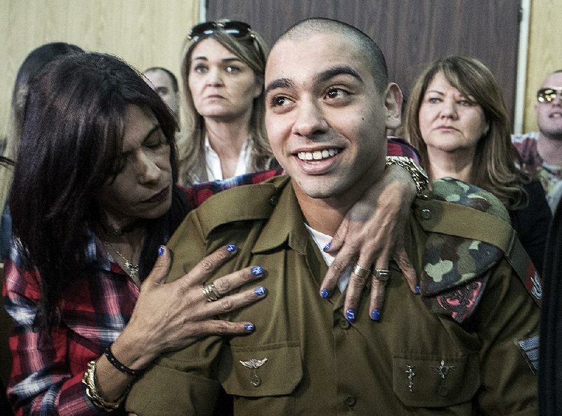 Israeli soldier Elor Azaria is embraced by his mother at the start of his sentencing hearing in Tel Aviv, Israel, Tuesday, Feb. 21, 2017.