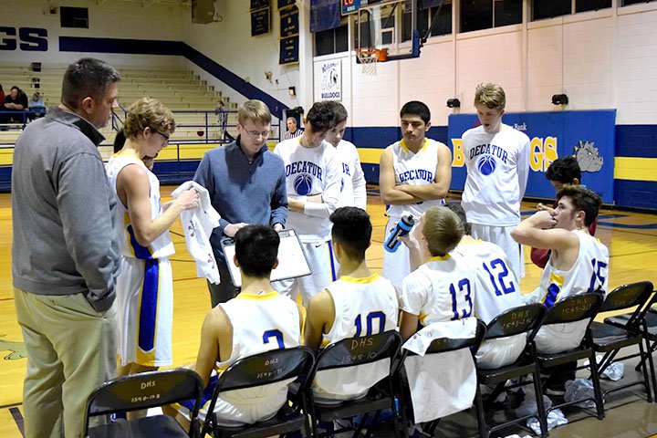 Photo by Mike Eckels Coach John Unger (center, left) mapped out a new game strategy on his clipboard during a timeout late in the third quarter of the Decatur-Lead Hill contest at Peterson Gym in Decatur Jan. 27.