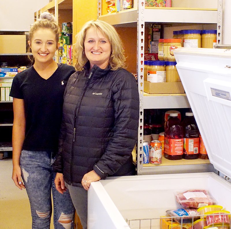 Photo by Randy Moll Chelsea Taylor and her mother, Angie Taylor, showed some of the foods on hand at the new GFA food pantry which will open Feb. 27 at the First Assembly of God in Gentry. Tentative hours will be 8 a.m. to 3 p.m. on Mondays by appointment.