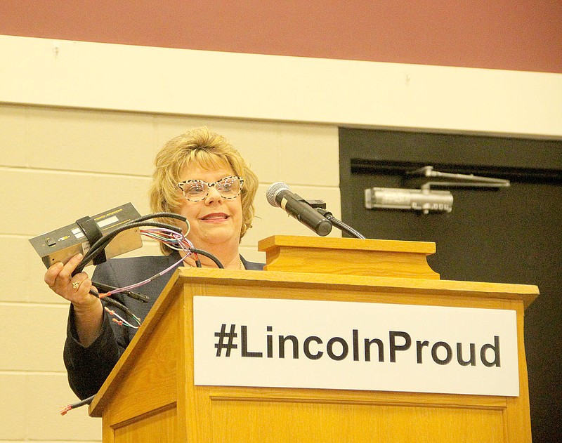 Marilyn Miles, owner of EMS Inc., in Dutch Mills, was the guest speaker for Lincoln Area Chamber of Commerce banquet on Friday night. She displays one of the electronics products produced by the 10-year-old firm.