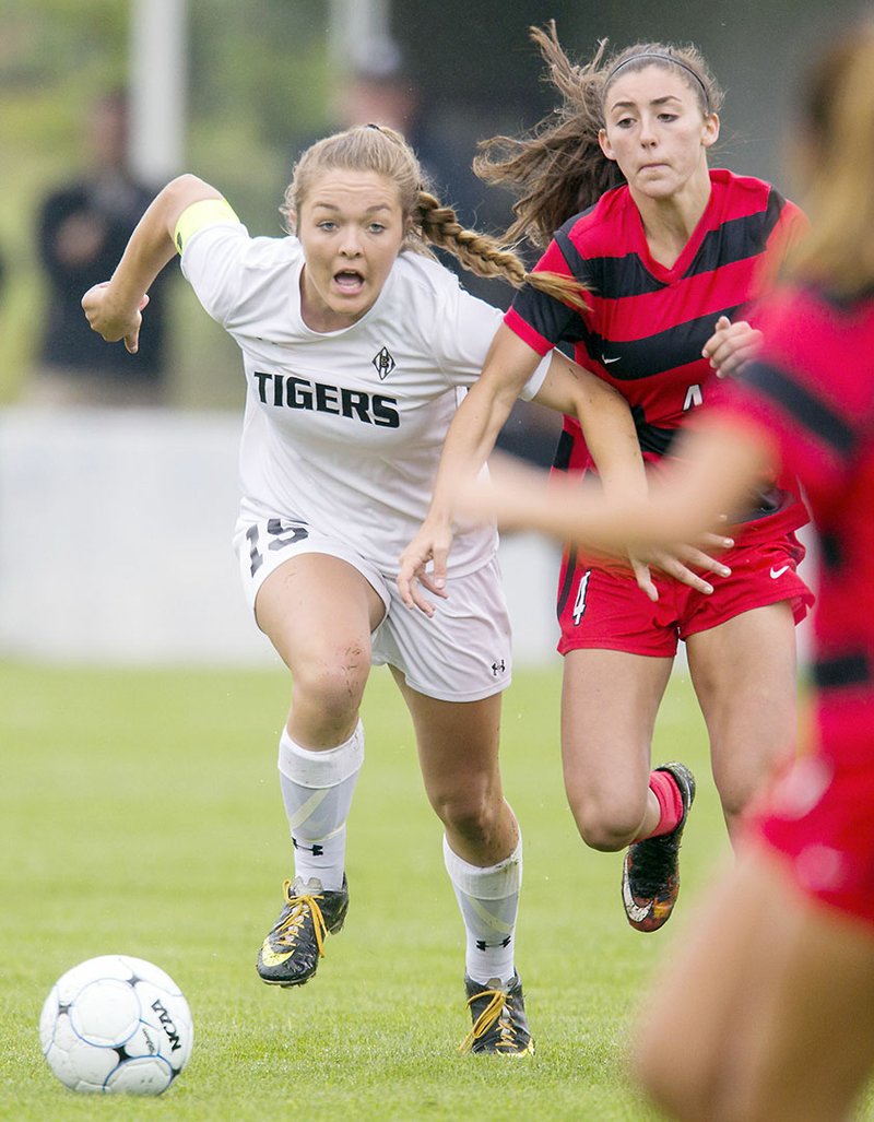 Cabot’s Hadley Dickinson, right, battles Bentonville’s Melanie Matkins for the ball during the Class 7A state-championship soccer game in Fayetteville last May. Dickinson recently signed to play soccer next year at the University of Central Arkansas in Conway.