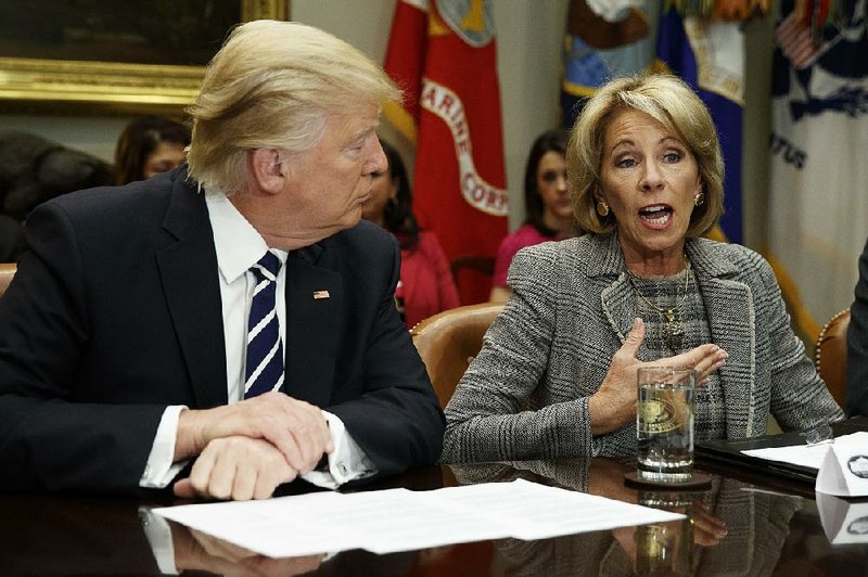 President Donald Trump listens as Education Secretary Betsy DeVos speaks during a meeting with parents and teachers, Tuesday, Feb. 14, 2017, in the Roosevelt Room of the White House in Washington. 