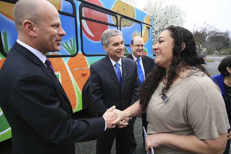 Katrina Betancourt, president and chief executive officer of the Arkansas Coalition for Obesity Prevention, talks with Troy Wells (from left), president and CEO of Baptist Health; Curtis Barnett, CEO of Arkansas Blue Cross and Blue Shield; and Patrick O’Sullivan, executive director of the Blue and You Foundation, after Betancourt’s organization received a grant from the foundation to implement wellness programs.