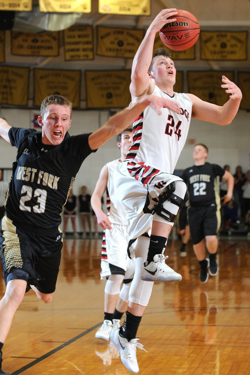 Westin Church (24) of Pea Ridge drops in a layup as West Fork’s Justin Bivens attempts to block the shot Wednesday during the 4A-North Regional Tournament at the Tiger Dome in West Fork. Visit nwadg.com/photos for more pictures from the game.