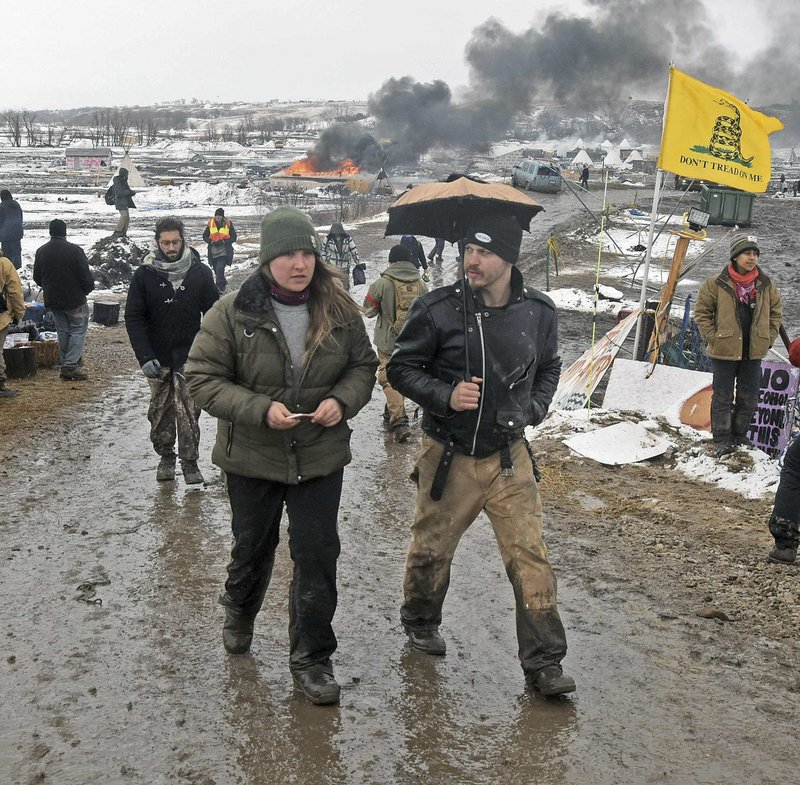 Tribune Tori Ramos, left, and Riley Cogburn, both of Albany, N.Y., leave as opponents of the Dakota Access pipeline leave their main protest camp Wednesday, Feb. 22, 2017, near Cannon Ball, N.D. Most of the pipeline opponents abandoned their protest camp Wednesday ahead of a government deadline to get off the federal land, and authorities moved to arrest some who defied the order in a final show of dissent. 