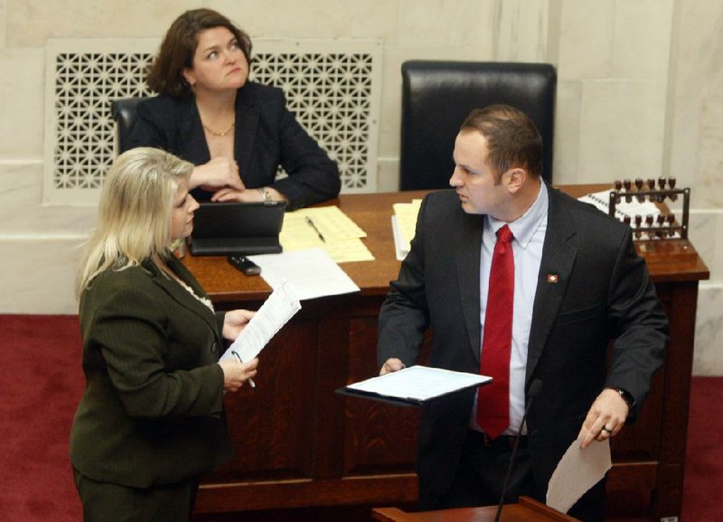 Republican Sens. Linda Collins-Smith of Pocahontas and Trent Garner of El Dorado talk Thursday on the Senate floor about pulling the campus-guns bill from consideration. Sitting behind them is Cindy Herron, Senate assistant public information officer. 