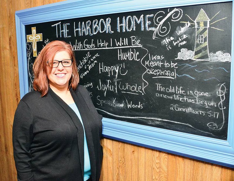 Lauralise Hodges stands in front of a chalkboard sign in the hallway of The Harbor Home in Conway, a residential facility for women with substance abuse. Hodges, a former drug addict, turned her life around and is program director for The Harbor Home. It is located inside The Harbor church at 18 Ranchette Road.