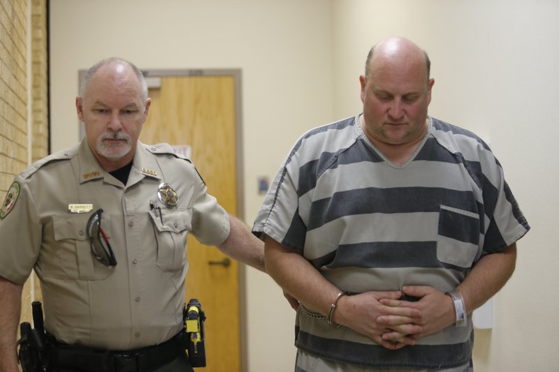 A Benton County Sheriff's Office deputy accompanies Grant Hardin (right) as he is led into the Benton County Courthouse Friday. Hardin was arrested in connection with the death of James Appleton, Sheriff Shawn Holloway said.