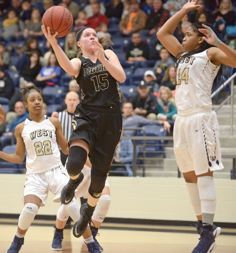  Abby Roberts (15) of Bentonville High maneuvers for a layup Friday as Imani Montgomery (24) of Bentonville West defends at Wolverine Arena in Centerton.