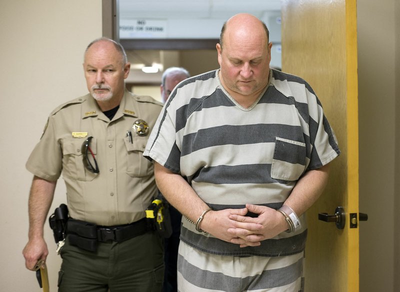 A Benton County Sheriff’s Office deputy accompanies Grant Hardin (right) as he is led Friday for his bond hearing at the Benton County Courthouse in Bentonville. Hardin was arrested in connection with the death of James Appleton, Sheriff Shawn Holloway said.