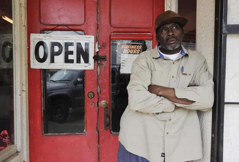 In this Feb. 15, 2017 photo, businessman Homer King stands outside his small store in Marion, Ala. King, who lives in the old plantation region called the Black Belt, says he is praying for President Donald Trump despite misgivings about his election. 