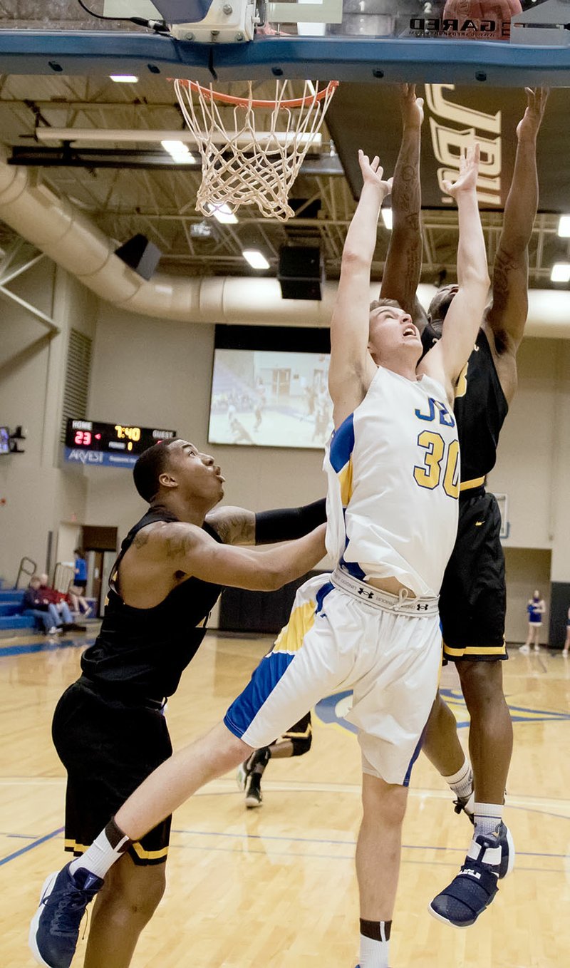 Photo courtesy of JBU Sports Information John Brown sophomore Benjamin Smith battles under the basket for a rebound in the first half Thursday against Texas Wesleyan. The Rams defeated JBU 78-76 to clinch a share of the league title.