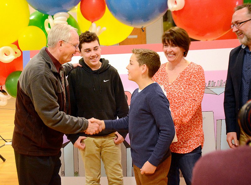 Janelle Jessen/Siloam Sunday Keenan Huckeby, a fifth-grade student at Siloam Springs Intermediate School, was congratulated by Superintendent Ken Ramey for being the Arkansas winner of the Doodle 4 Google competition as his brother Reece Huckeby and parents Paula and Jon Huckeby looked on. Google employees surprised Huckeby with the award during a school assembly on Thursday. Huckeby and 52 other winners, representing all the U.S. states and territories, will move on to the second stage of the competition where five national finalists will be selected by public vote. Votes may be cast online at www.doodle4google.com through March 5.