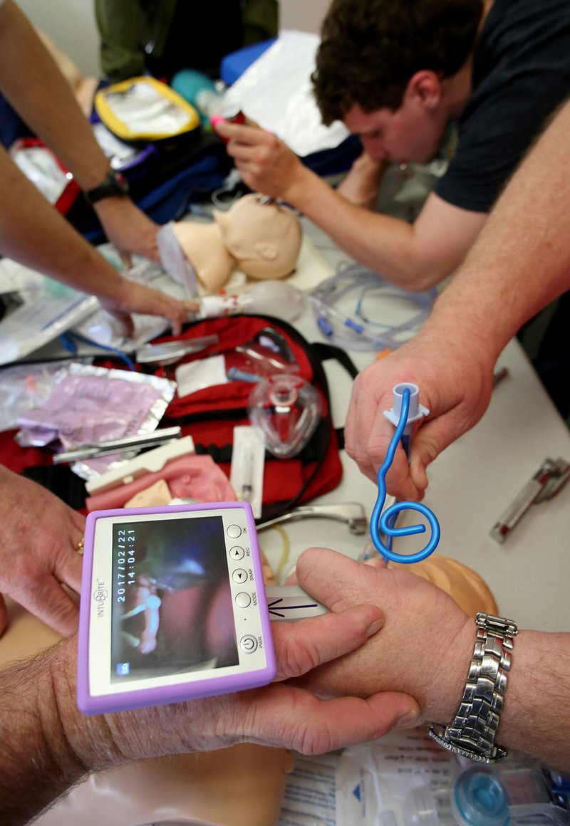 Paramedic Doug McCratic (right) trains on intubation on both infant and child mannequins at the Central EMS training facility in Fayetteville.