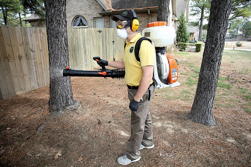 Brad Simon, owner of a Mosquito Joe franchise, sprays the front yard of a home in Springdale. His franchise was one of the top operators in the chain last year.