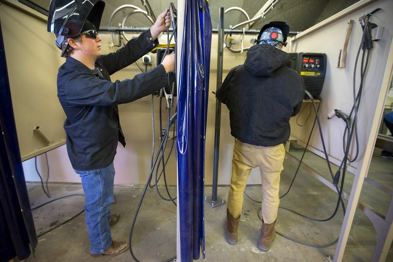 Alex Lopez (left), Gravette High School junior, and Dylan Whitford, Bentonville High School senior, work on a welding project Thursday during class at the Western Benton County Career Center in Gravette.