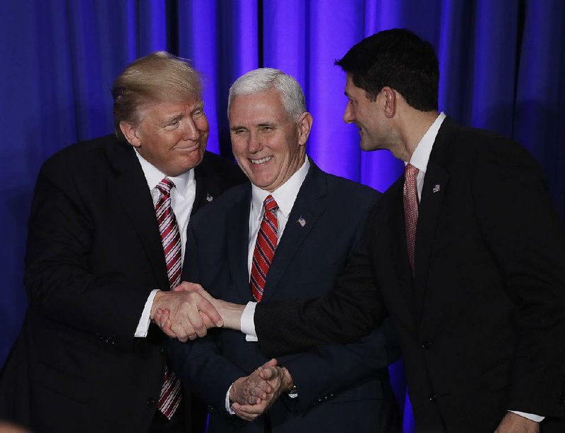 With Vice President Mike Pence stuck in the middle, President Donald Trump (left) shakes hands with House Speaker Paul Ryan on Jan. 26. Trump will speak to Congress at 8 p.m. today.