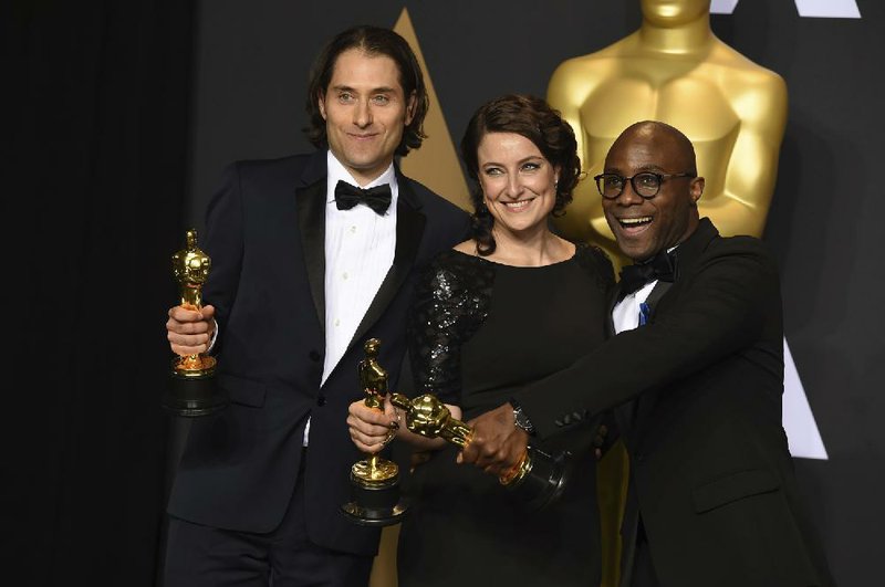 Jeremy Kleiner (from left), Adele Romanski and Barry Jenkins, winners of the Academy Award for best picture for Moonlight, pose Sunday at the Dolby Theatre in Los Angeles.