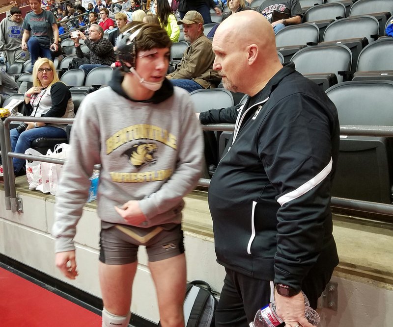 Bentonville assistant wrestling coach Bill Desler (right) talks to his son, Nathan, before one of his matches in the Class 6A-7A Arkansas High School State Wrestling tournament in Little Rock. Desler will be honored for his “Lifetime Service to Wrestling” in the National Wrestling Hall of Fame in Stillwater, Okla.