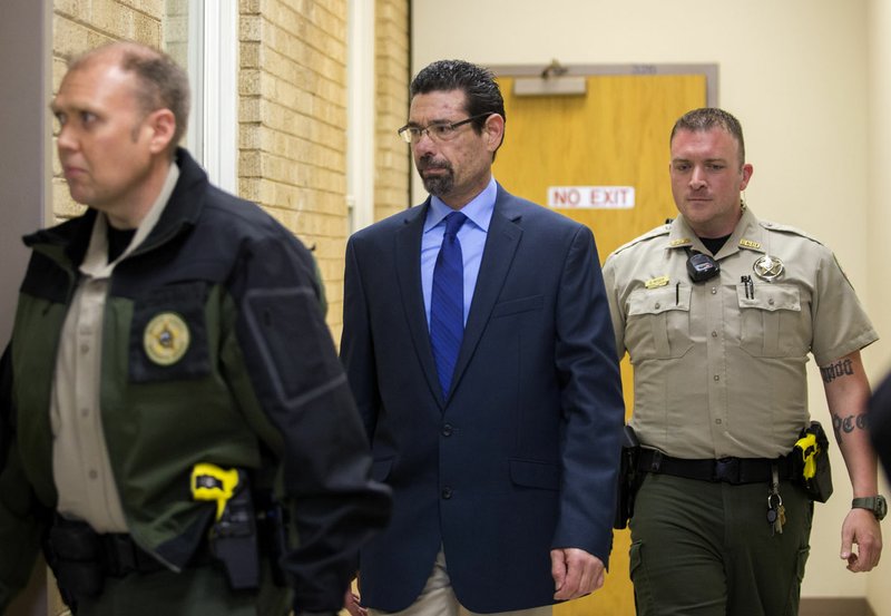 Benton County Sheriff’s Office deputies accompany Brian Post (center), 48, of Springdale, as he is led Friday into the Benton County Courthouse in Bentonville. Post is charged with attempted capital murder, five counts of rape and first-degree battery.