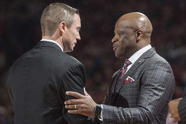 Arkansas head coach Mike Anderson (right) chats with Florida head coach Mike White before the game Thursday Dec. 29, 2016, at Bud Walton Arena in Fayetteville.