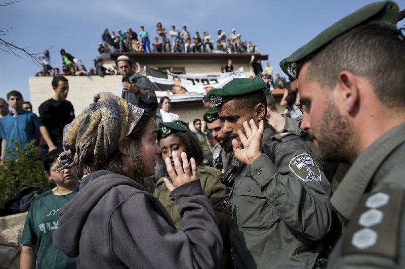 A settler argues with Israeli police Tuesday in the West Bank settlement of Ofra. 