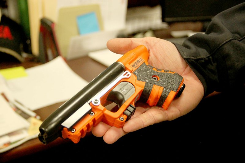 LYNN KUTTER ENTERPRISE-LEADER Prairie Grove Police Chief Chris Workman displays one of the department&#8217;s new pepper spray guns. The gun is orange and black.