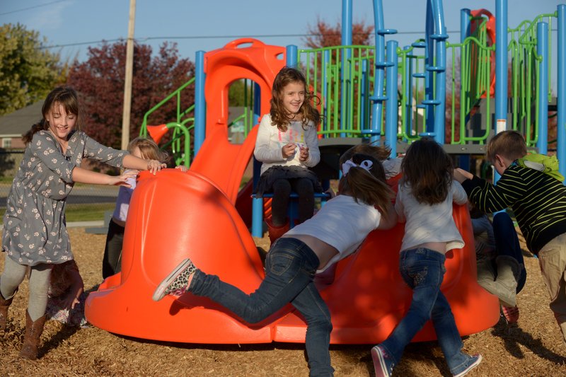 NWA Democrat-Gazette/BEN GOFF @NWABENGOFF
Josie Riethmaier, 6, sits in the center as her friends spin a playground feature on Friday Nov. 11, 2016 during her birthday party at Wildwood Park in Bentonville. Bright Field Middle School students helped redesign the playground at the park, which reopened this week. 