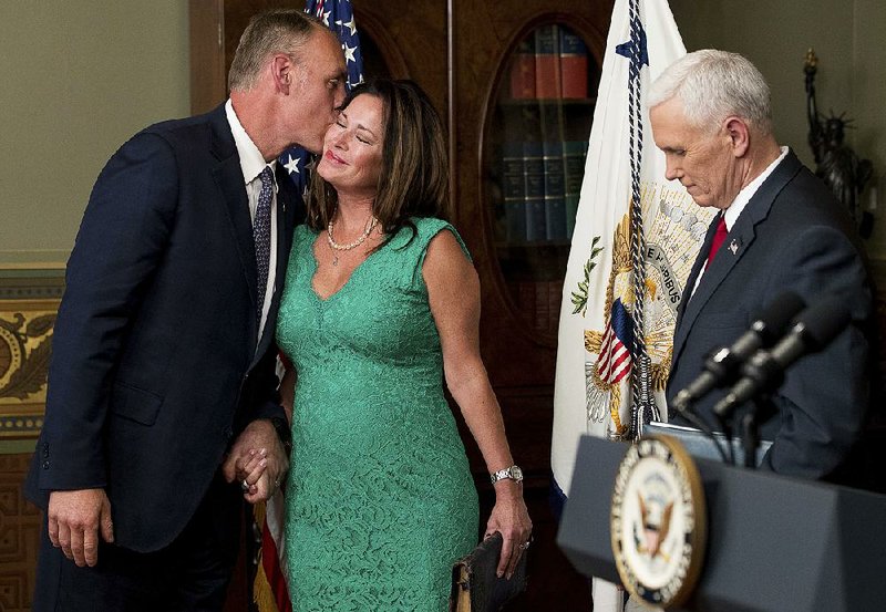 New Interior Secretary Ryan Zinke kisses his wife, Lolita Hand, after he was sworn in Wednesday by Vice President Mike Pence at the Eisenhower Executive Office Building in Washington.