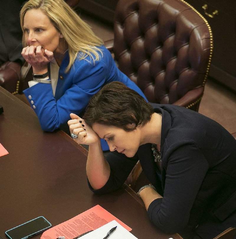 Rep. Jana Della Rosa hangs her head Wednesday after the House approved expanded grocery store wine sales. Della Rosa had opposed reconsidering the bill. At left is Rep. DeAnn Vaught, R-Horatio.